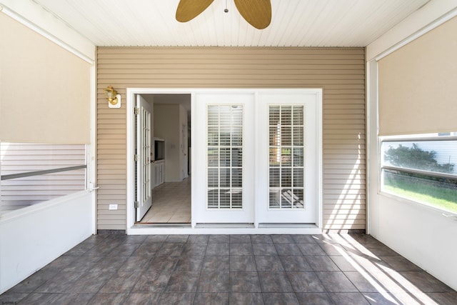 unfurnished sunroom featuring a ceiling fan