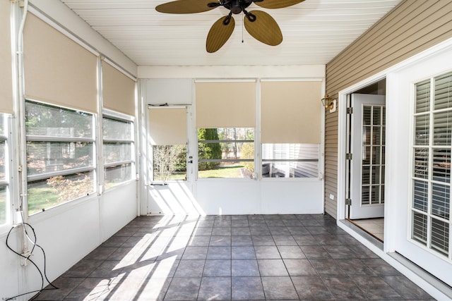 unfurnished sunroom featuring ceiling fan
