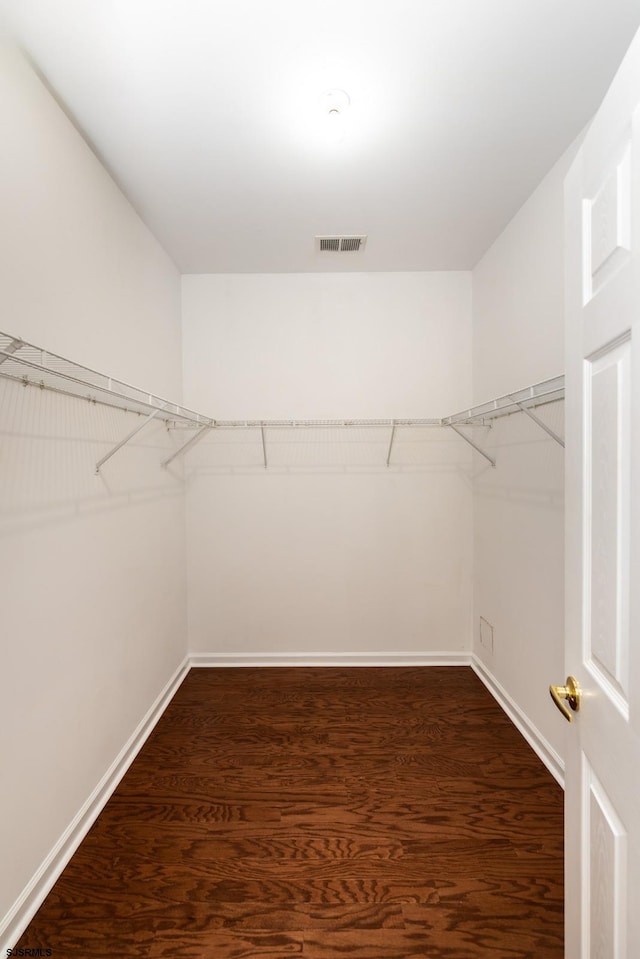 walk in closet featuring visible vents and dark wood-style floors