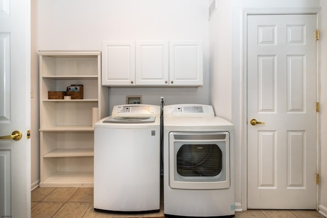 laundry area featuring light tile patterned floors, visible vents, baseboards, cabinet space, and washer and clothes dryer