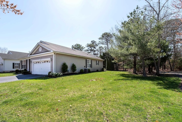 view of home's exterior featuring a lawn, aphalt driveway, central AC, and an attached garage