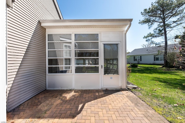 entrance to property with a patio and a lawn
