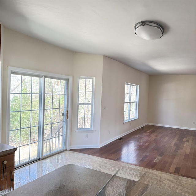 interior space featuring visible vents, baseboards, and hardwood / wood-style floors
