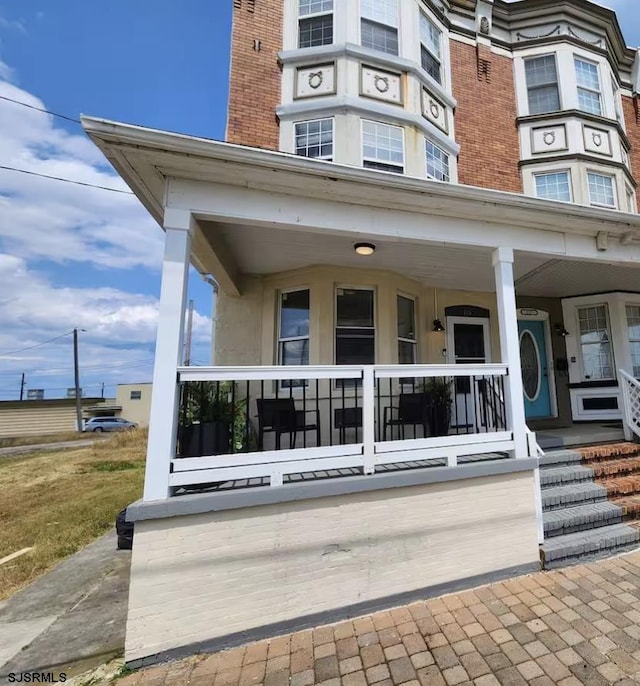 exterior space featuring brick siding and a porch