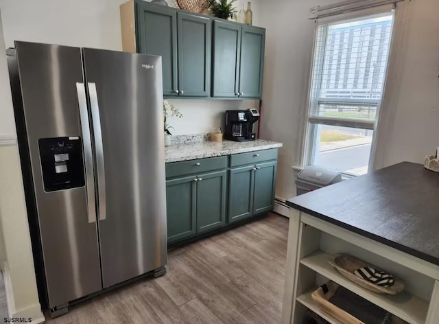 kitchen featuring stainless steel fridge with ice dispenser, a baseboard radiator, light countertops, and wood finished floors