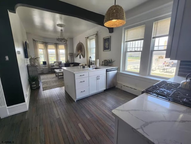 kitchen featuring an inviting chandelier, a sink, open floor plan, a peninsula, and stainless steel dishwasher