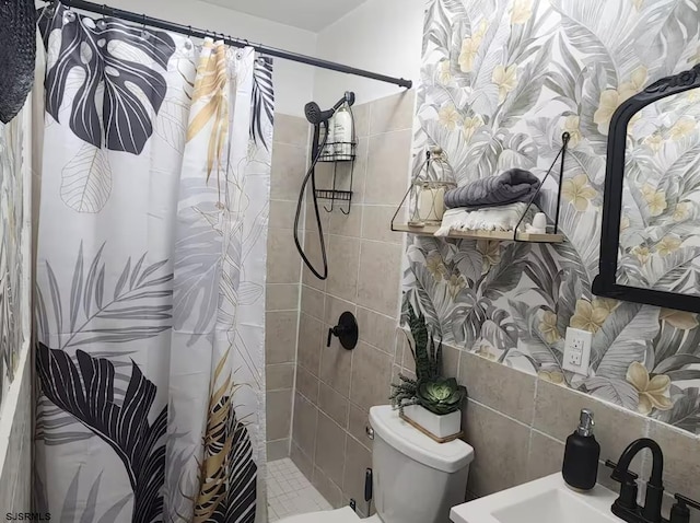 full bath with tiled shower, tile walls, a sink, and toilet