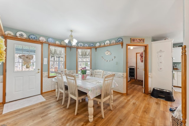 dining room featuring light wood-type flooring and a notable chandelier