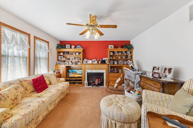 living area featuring ceiling fan, visible vents, carpet flooring, and a high end fireplace