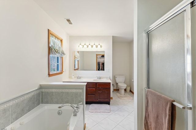 full bath with tile patterned floors, a bath, double vanity, toilet, and visible vents