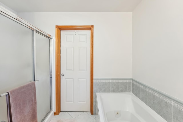 bathroom featuring a bath, tile patterned flooring, and a stall shower