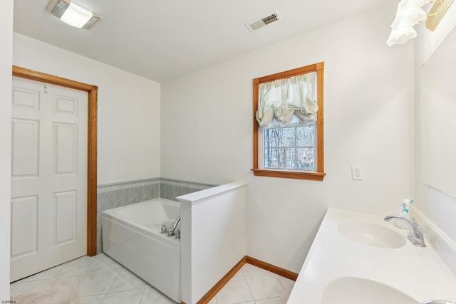 bathroom featuring a bath, tile patterned flooring, a sink, and visible vents