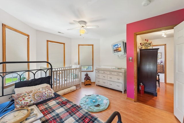 bedroom featuring a ceiling fan, wood finished floors, and visible vents