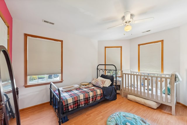 bedroom featuring a ceiling fan, wood finished floors, and visible vents