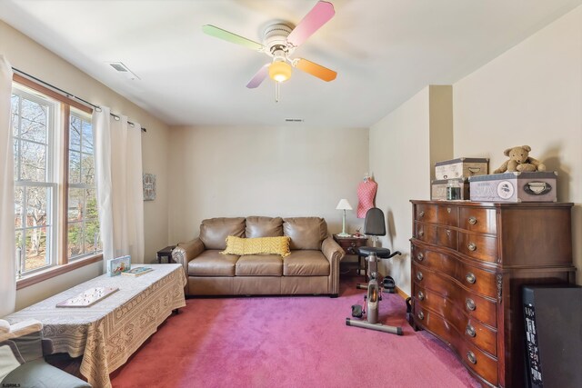 carpeted living room with visible vents, ceiling fan, and a healthy amount of sunlight