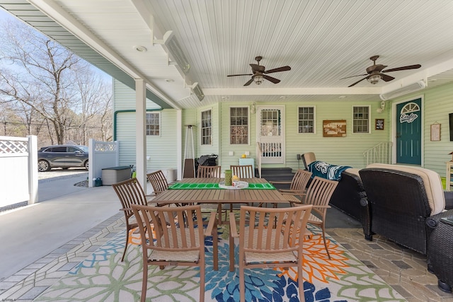 view of patio featuring a ceiling fan, outdoor dining area, and fence