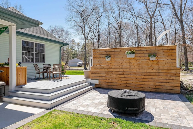 view of patio / terrace featuring a wooden deck and an outdoor fire pit