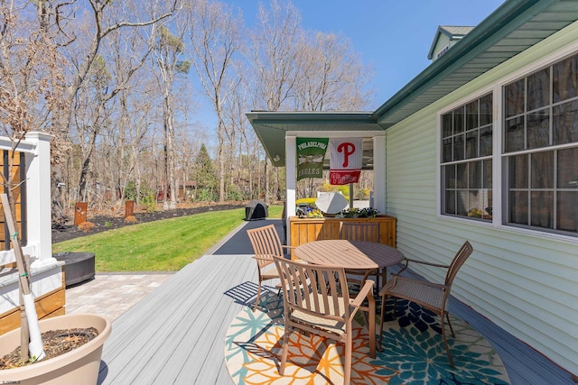 wooden terrace with a lawn and outdoor dining area