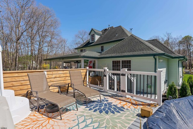 rear view of house with a ceiling fan, roof with shingles, and a patio