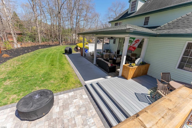 wooden deck with a lawn, a patio, ceiling fan, and an outdoor hangout area