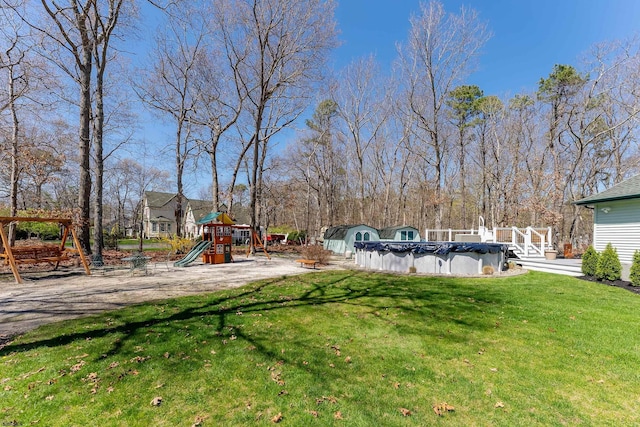 view of yard with a covered pool and a playground