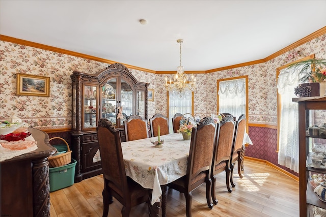 dining room featuring wainscoting, a notable chandelier, light wood finished floors, and wallpapered walls