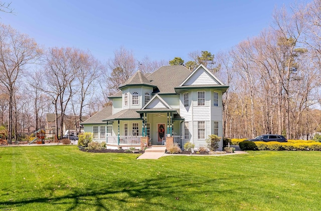 view of front facade featuring a front lawn, a playground, and covered porch