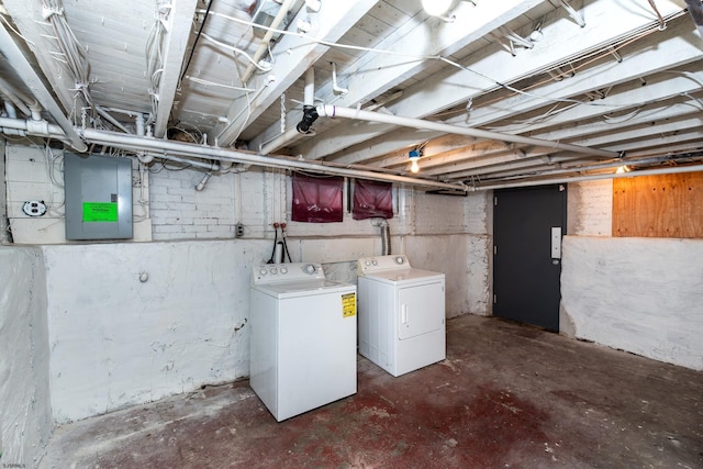 unfinished basement featuring electric panel and washer and dryer