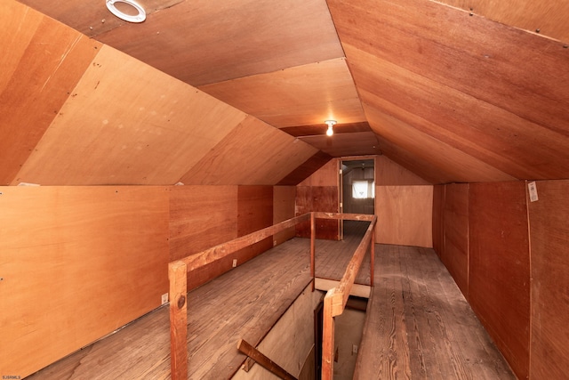 bonus room with wooden walls, vaulted ceiling, and wood finished floors