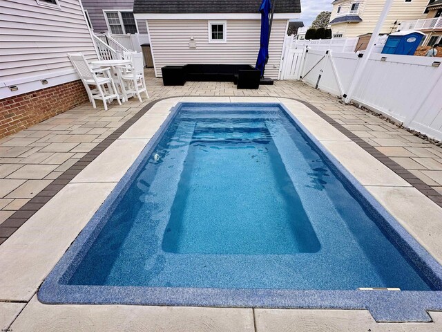22 Spruce Rd, Ocean City, NJ 08226 - view of pool featuring an outbuilding, a fenced backyard, a storage unit, and a patio