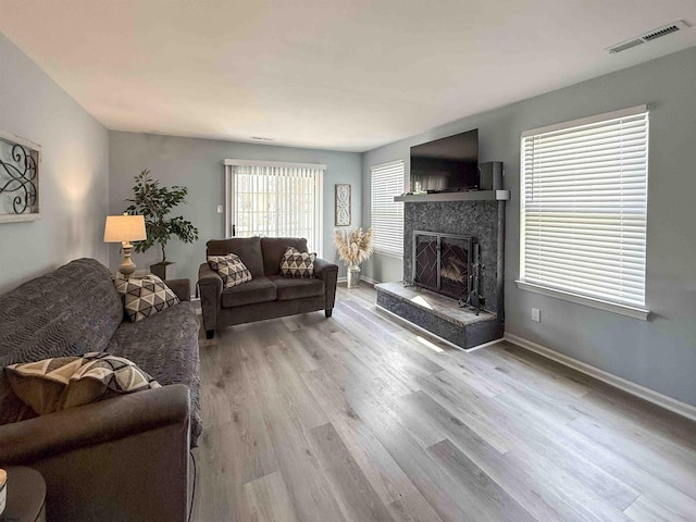 722 Fishers Creek Rd, Galloway Township, NJ 08205 - living area with wood finished floors, a fireplace with raised hearth, baseboards, and visible vents