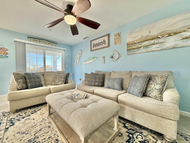carpeted living area featuring visible vents, baseboards, and ceiling fan