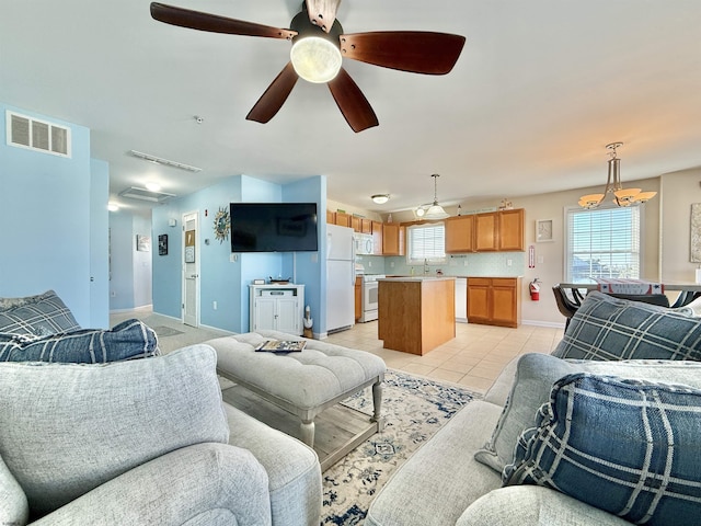 living room with visible vents, baseboards, ceiling fan, and light tile patterned floors