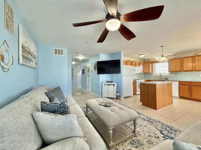 living area featuring visible vents, ceiling fan, and light tile patterned floors