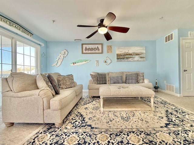 carpeted living room with baseboards, a ceiling fan, and visible vents