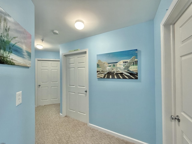 hallway with baseboards and carpet flooring