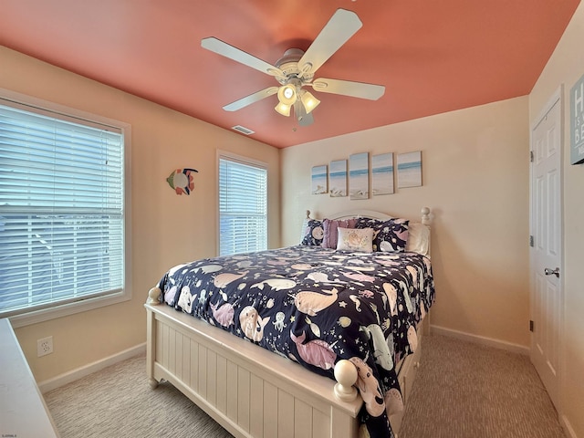 carpeted bedroom featuring visible vents, baseboards, and a ceiling fan