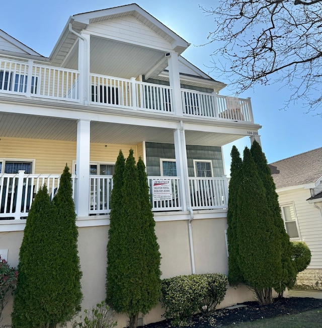 view of side of property with covered porch and stucco siding