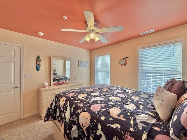 carpeted bedroom with visible vents, ceiling fan, and baseboards