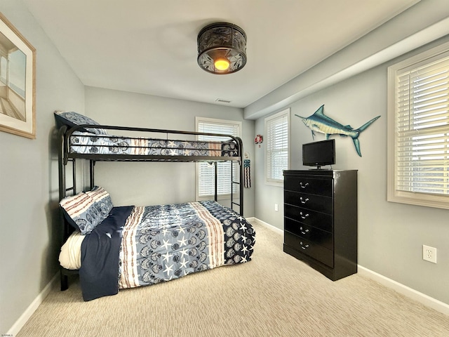 carpeted bedroom featuring visible vents and baseboards