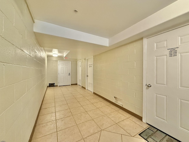 interior space featuring light tile patterned floors and concrete block wall