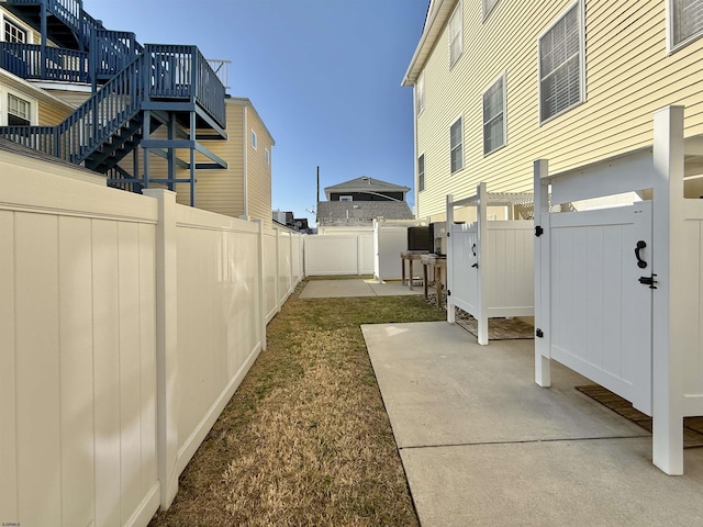 view of yard featuring a patio area, a fenced backyard, and stairs