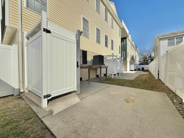 view of side of home featuring a patio and a fenced backyard