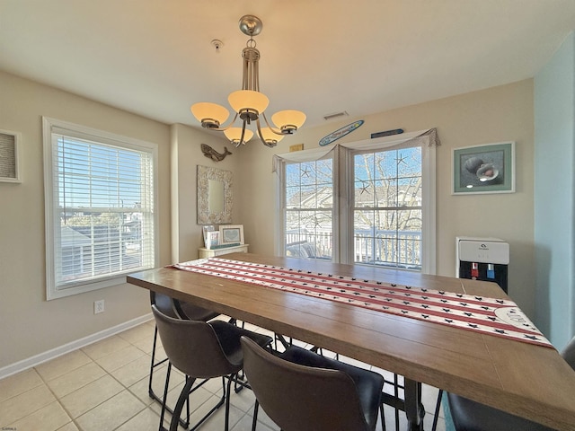 dining area featuring a chandelier, light tile patterned flooring, baseboards, and a wealth of natural light
