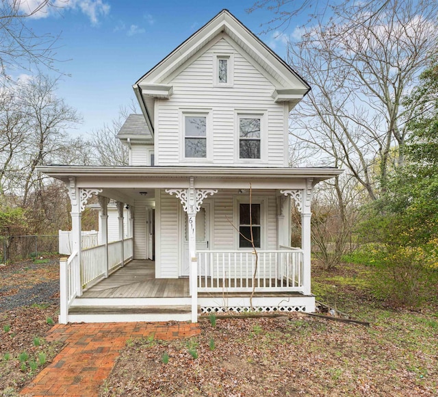 view of front of property with a porch and fence