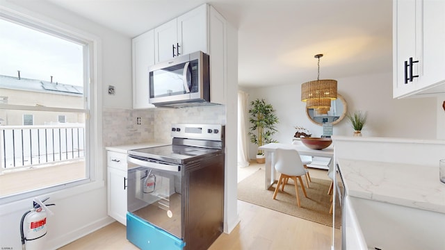 kitchen featuring tasteful backsplash, light wood-type flooring, plenty of natural light, and stainless steel appliances