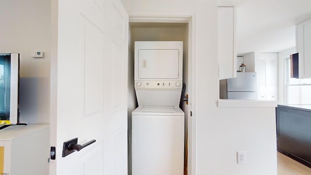 clothes washing area with laundry area and stacked washer / drying machine