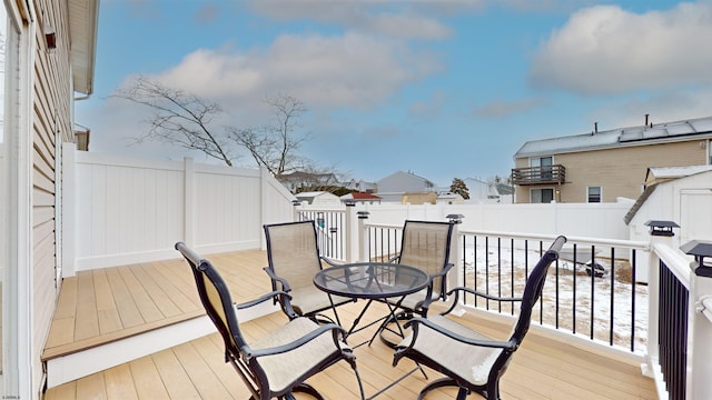 deck featuring an outbuilding, a fenced backyard, outdoor dining area, and a shed