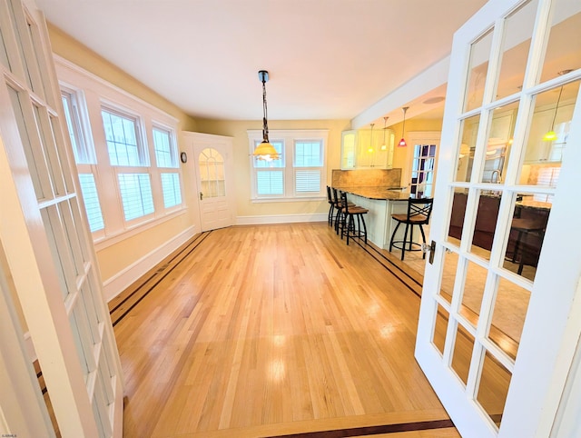 unfurnished dining area with light wood finished floors and baseboards