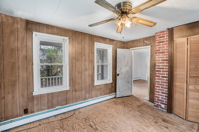 611-615 S New York Rd, Galloway Township, NJ 08205 - unfurnished bedroom with a baseboard heating unit, wood walls, ceiling fan, a closet, and wood finished floors